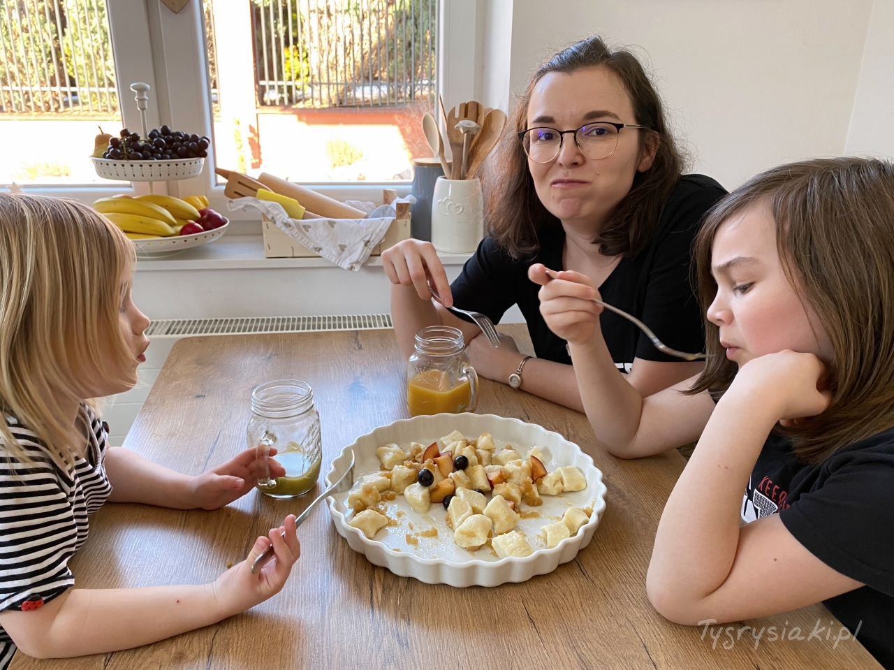 mama i dzieci przy stole jedzą kluski
